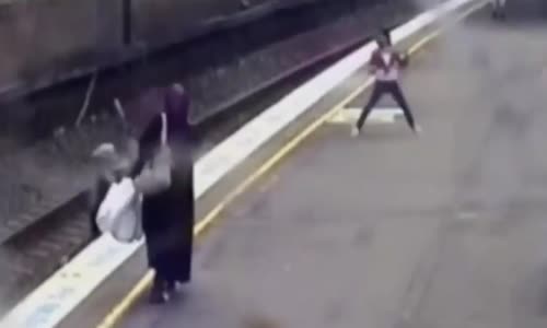 Woman saves schoolgirl from train tracks 