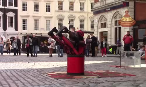 Flexible man climbs into a tiny glass box